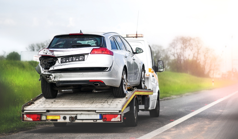 An accident-damaged vehicle is towed away