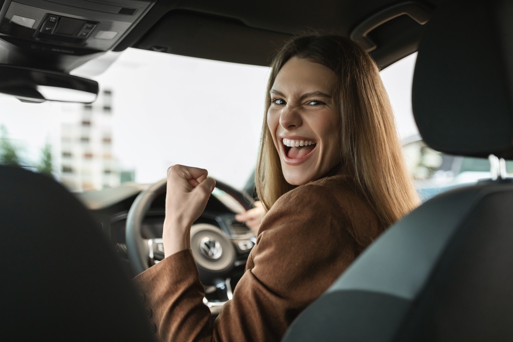 A woman is excited to get a good price when selling her car