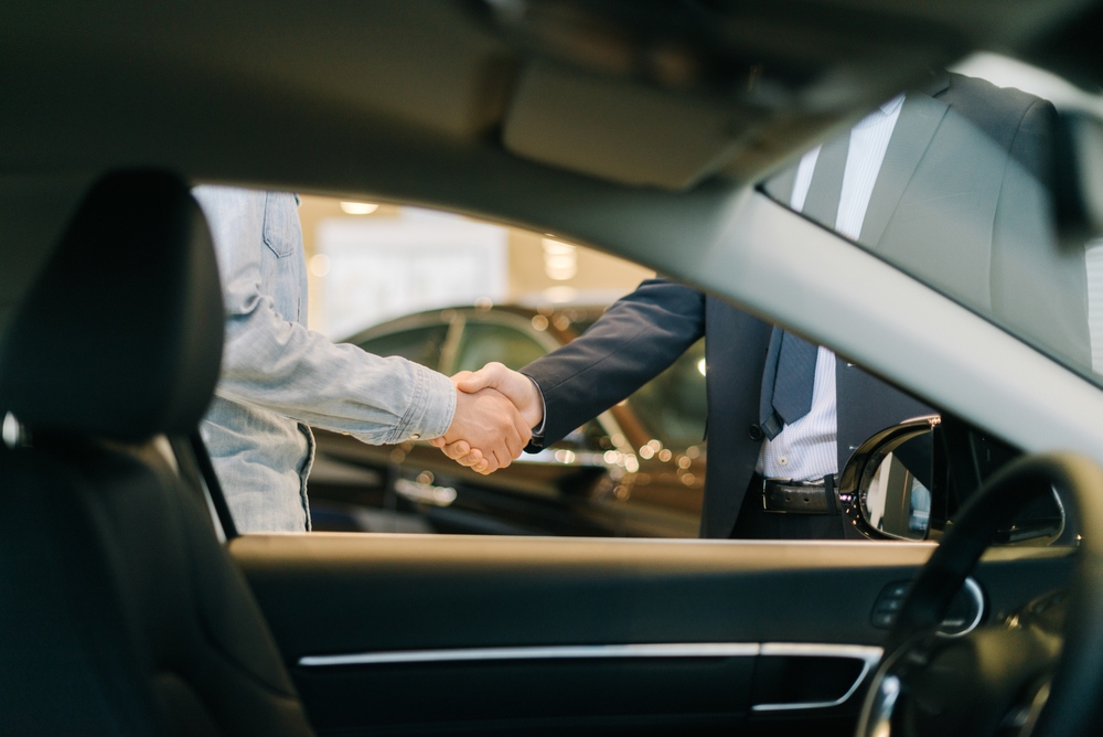 People shake hands following a successful car trade-in